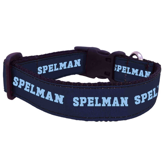 A navy blue pet collar with the text 'Spelman' printed in white.